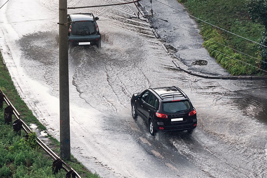Two cars driving through heavily flooded road