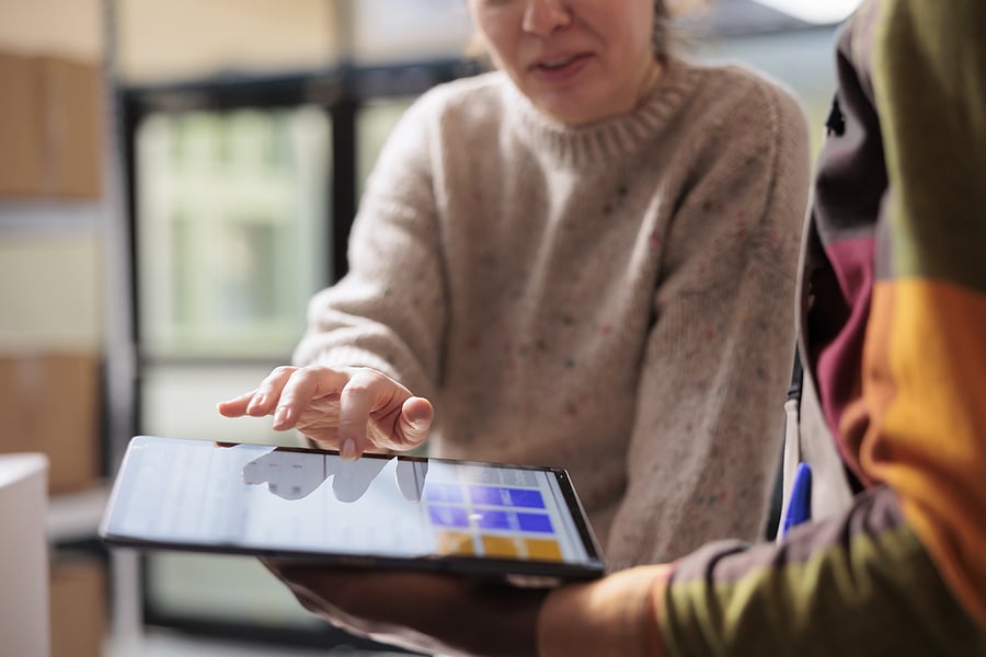 Coworkers using a tablet to update business inventory